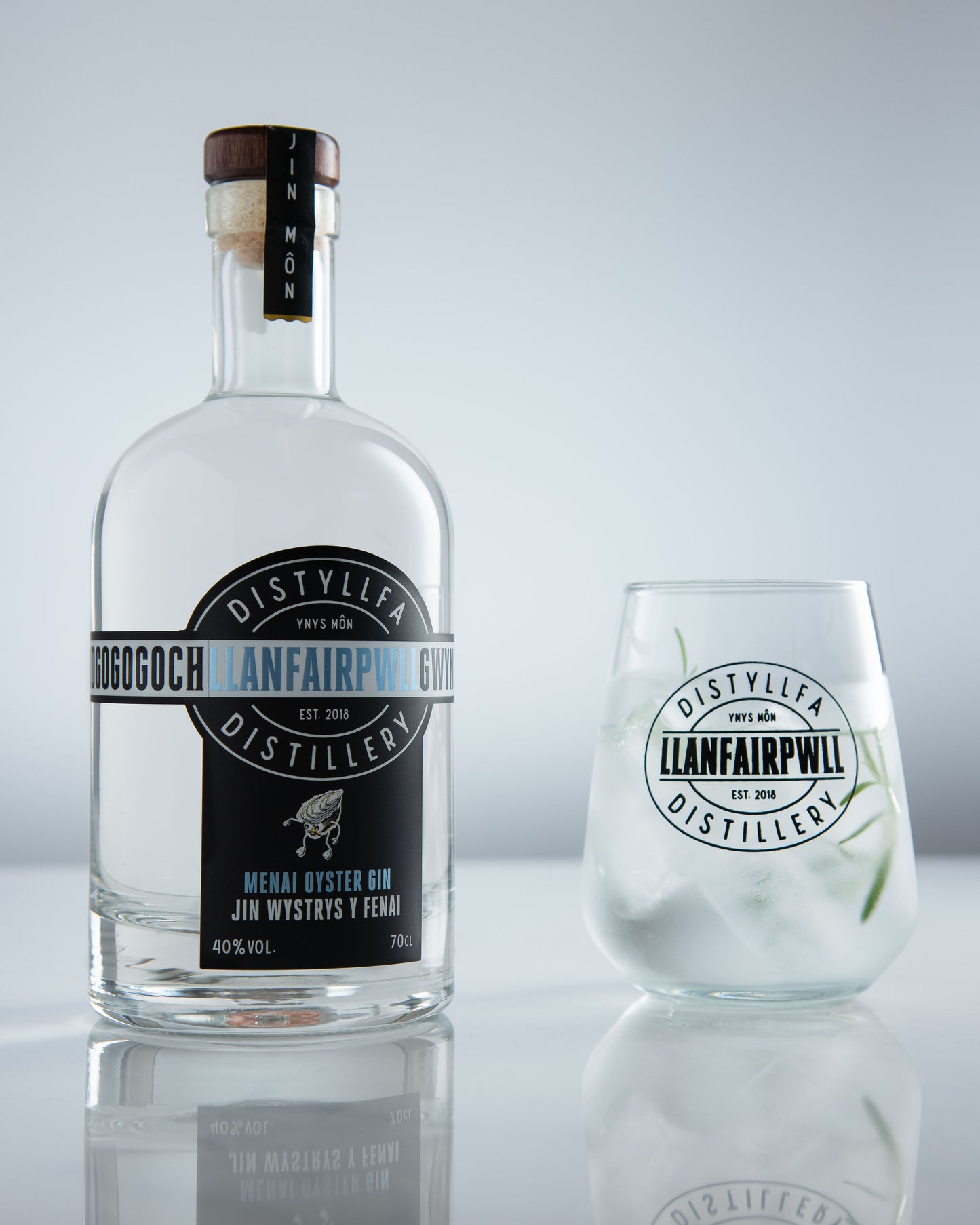 Menai Oyster Gin bottle next to a branded glass – Welsh coastal gin from Anglesey